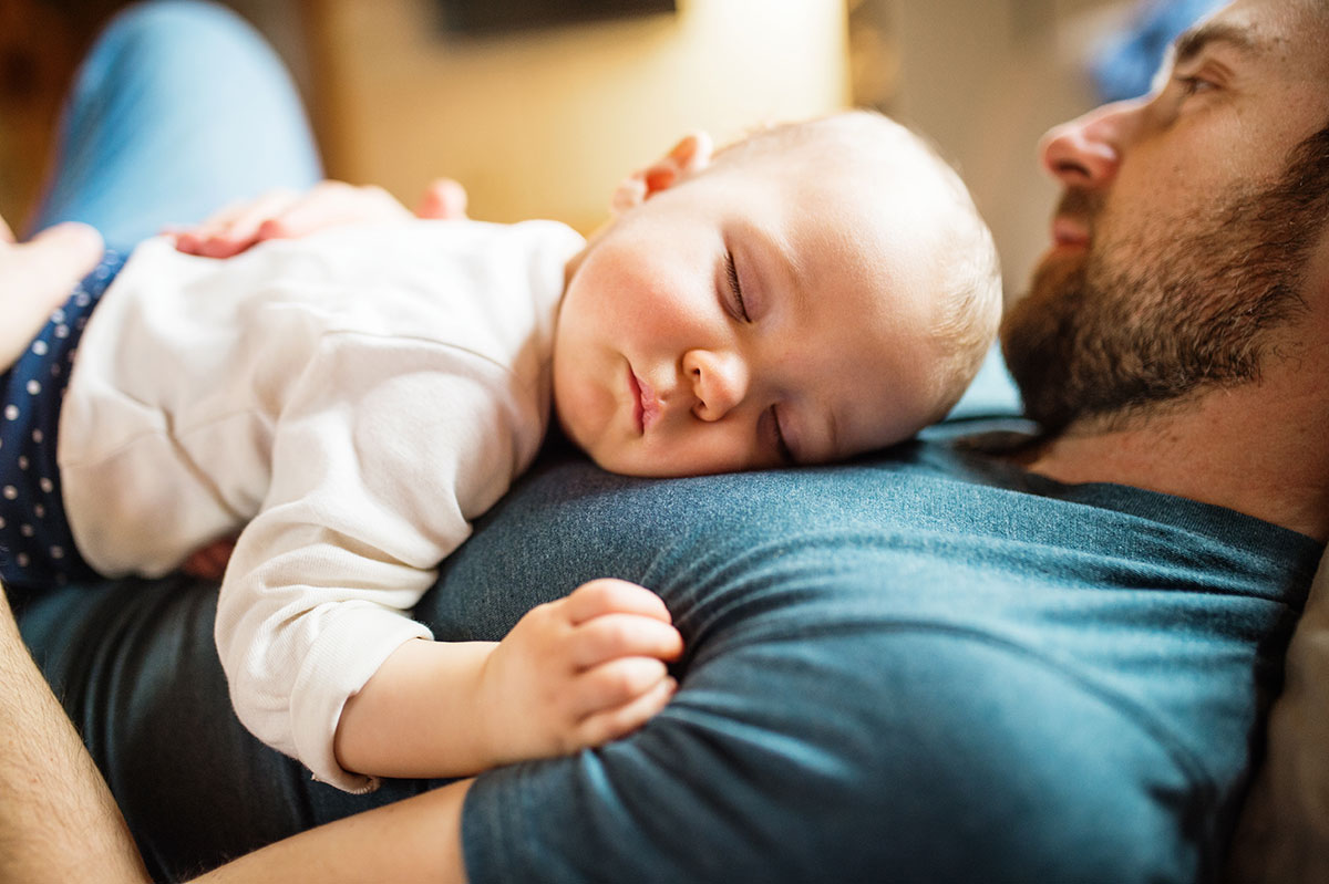 baby sleeps on father's chest