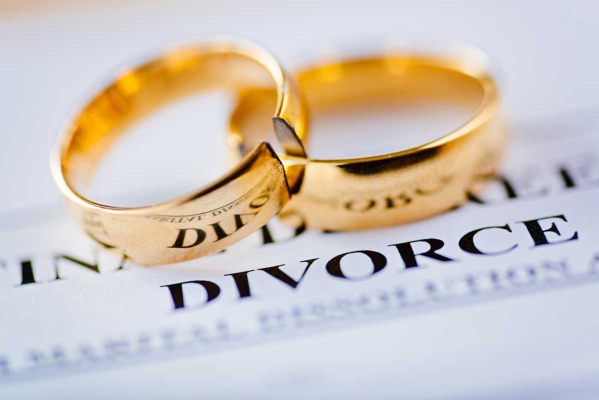 wedding rings on top of divorce papers