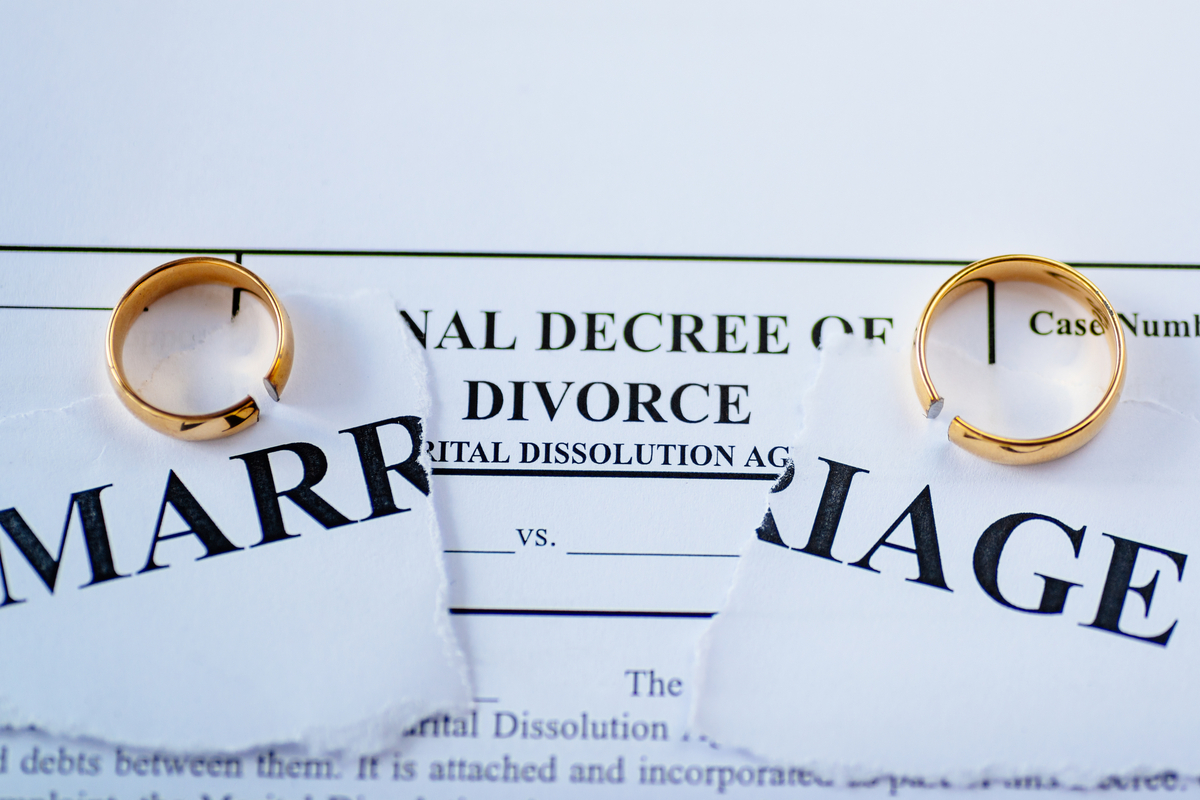 Two wedding rings on top of divorce papers